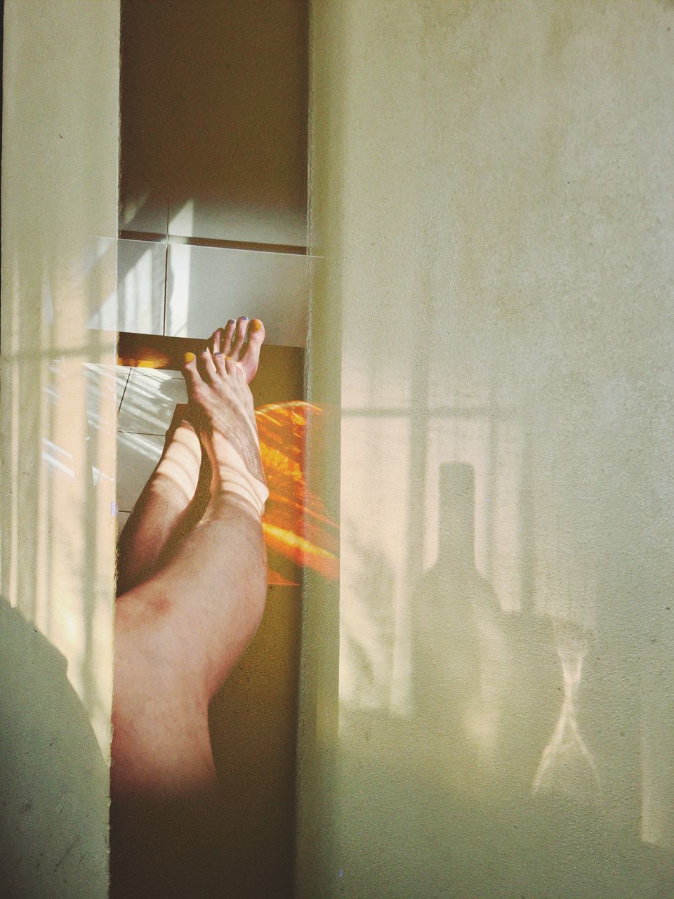 MIDSECTION OF WOMAN WITH HAND AGAINST CURTAIN