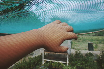 Close-up of person hand on swimming pool