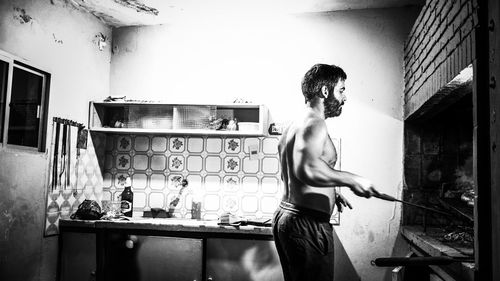 Shirtless man preparing food at home