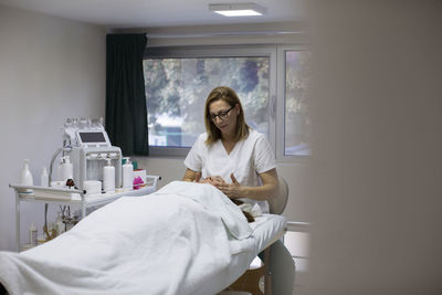 Young woman sitting on bed at home