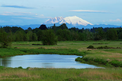 Scenic view of lake by mountain against sky