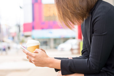 Midsection of woman holding coffee cup