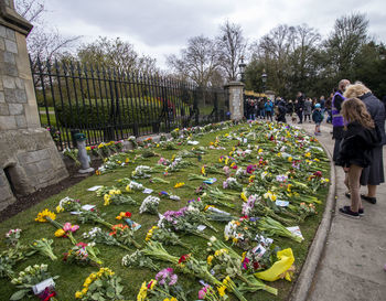 People at cemetery against sky