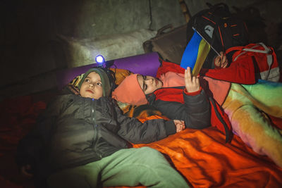 Kids with ukrainian flag lay in bomb shelter and waits for end of airstrike of russian invaders