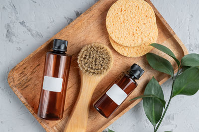 Fsce and body care spa treatment consept. two brown unbranded bottles, face brush and sponges 