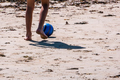 Low section of person playing with ball on beach