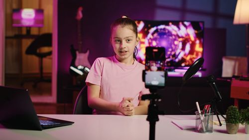 Portrait of young woman using laptop while sitting on table