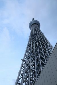 Low angle view of skyscraper against cloudy sky