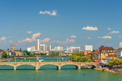 Bridge over river in city against sky