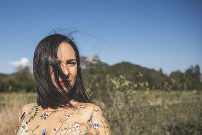 Portrait of woman standing on land against sky