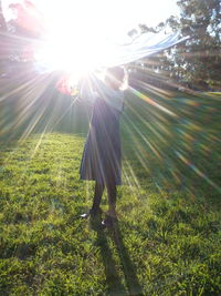 Rear view of woman standing on field