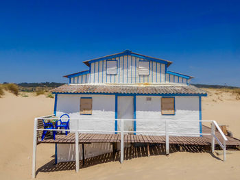 Built structure on beach against clear blue sky