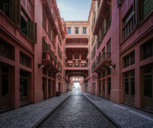 Empty road amidst buildings in city