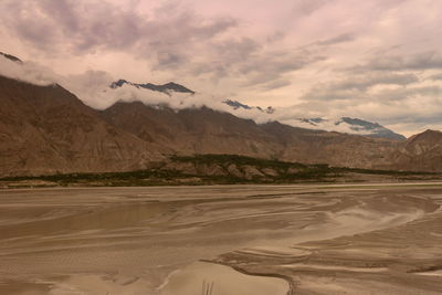 Scenic view of land and mountains against sky