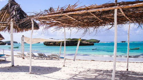 Scenic view of calm beach against blue sky