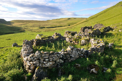 Stone structure on grassy landscape at isle of skye