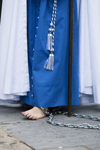 Low section of man wearing traditional clothing on footpath