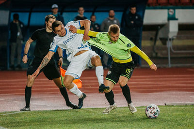 Group of people playing soccer on field