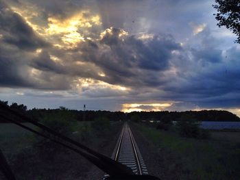 View of landscape against cloudy sky at sunset