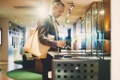 Businessman using id card at turnstile in office