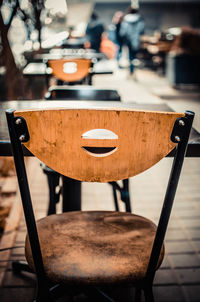 Empty chairs arranged by tables at sidewalk cafe