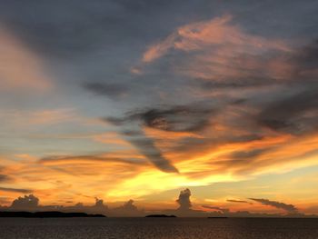 Scenic view of sea against dramatic sky during sunset