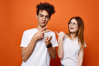 Portrait of young couple against orange background