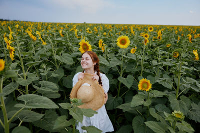 Young woman amidst yellow flowering plants