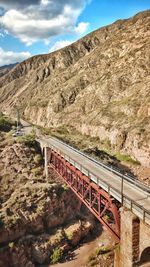 Bridge over mountain against sky