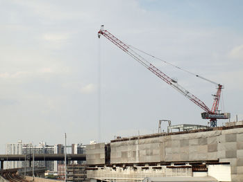 Cranes at construction site against sky