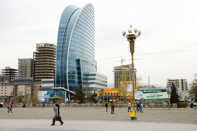 Street by buildings against sky in city