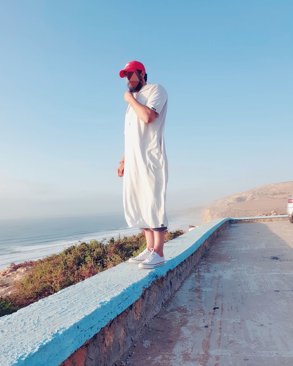 WOMAN STANDING ON SHORE AGAINST SEA AGAINST CLEAR SKY