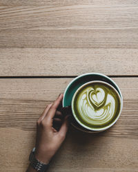 Directly above shot of hand holding coffee cup