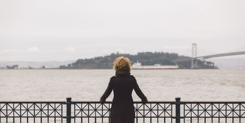 Rear view of woman looking at suspension bridge