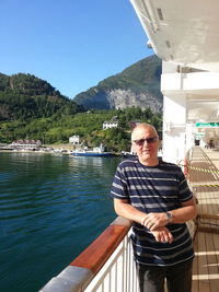 Portrait of man standing by lake