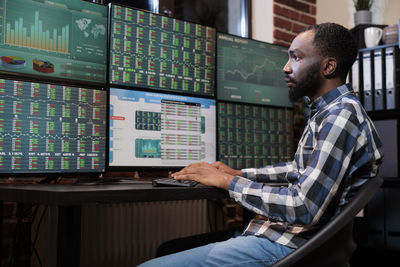 Side view of male trader trading in office