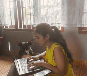 Young woman using mobile phone at home