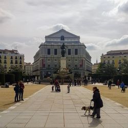 People walking on street against buildings in city