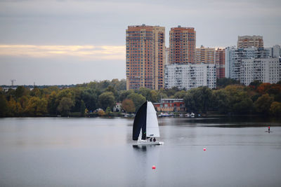 Scenic view of lake against buildings in city