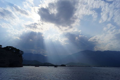 Scenic view of sea and mountains against sky