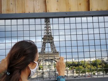 Rear view of woman against sky in city