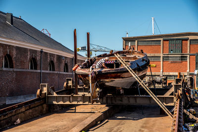 Boats moored at harbor against clear sky