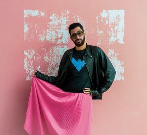 Portrait of young man standing against wall