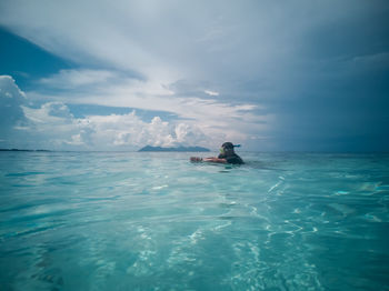 Man in sea against sky