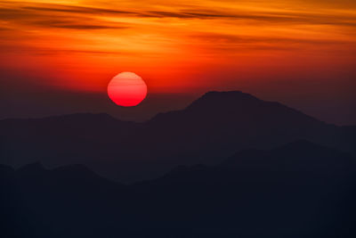 Scenic view of silhouette mountains against romantic sky at sunset