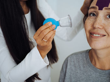 Close up portrait woman on cosmetologist massage session doing anti age procedures with vacuum cups