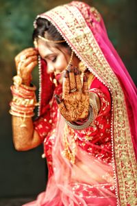 Close-up of woman holding red berries against blurred background