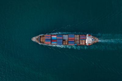 Containers ship corgo logistic transportation floating at sea aerial top view