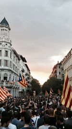 People at beach against sky in city