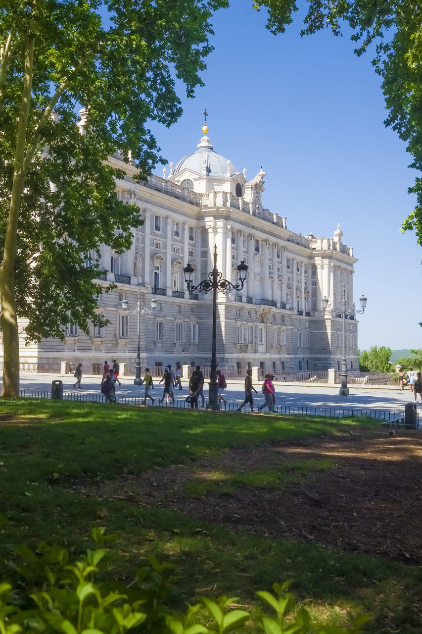 architecture, built structure, building exterior, plant, travel destinations, travel, nature, tree, tourism, sky, history, the past, city, château, group of people, estate, day, grass, clear sky, government, building, outdoors, tourist, landmark, palace, sunny, blue